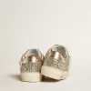 May Junior en paillettes platine avec étoile en cuir métallisé et languette au talon May Junior en paillettes platine avec étoile en cuir métallisé et languette au talon