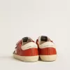 Modèle Junior Old School en cuir nappa orange avec étoile blanche et languette en cuir crème au talon. Modèle Junior Old School en cuir nappa orange avec étoile blanche et languette en cuir crème au talon.