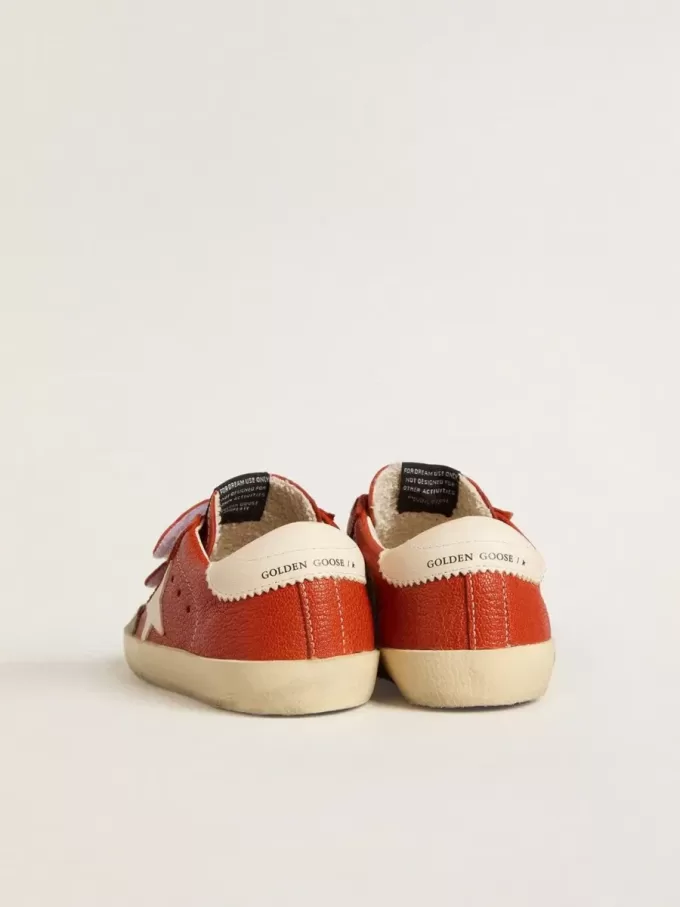 Modèle Junior Old School en cuir nappa orange avec étoile blanche et languette en cuir crème au talon. Modèle Junior Old School en cuir nappa orange avec étoile blanche et languette en cuir crème au talon.