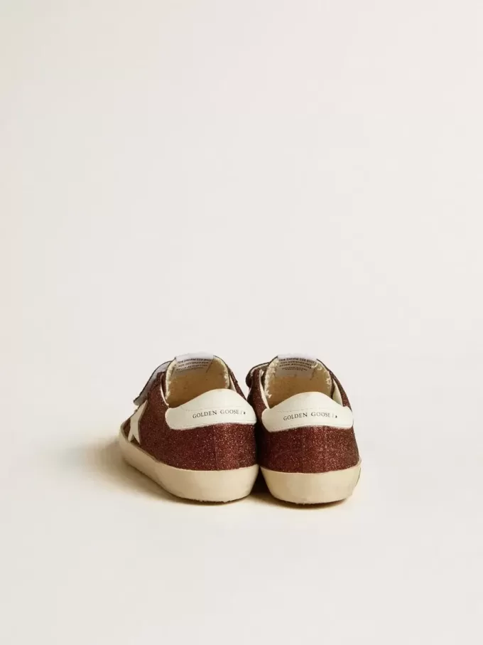 Modèle Old School Junior bordeaux pailleté avec étoile et languette au talon en cuir Modèle Old School Junior bordeaux pailleté avec étoile et languette au talon en cuir